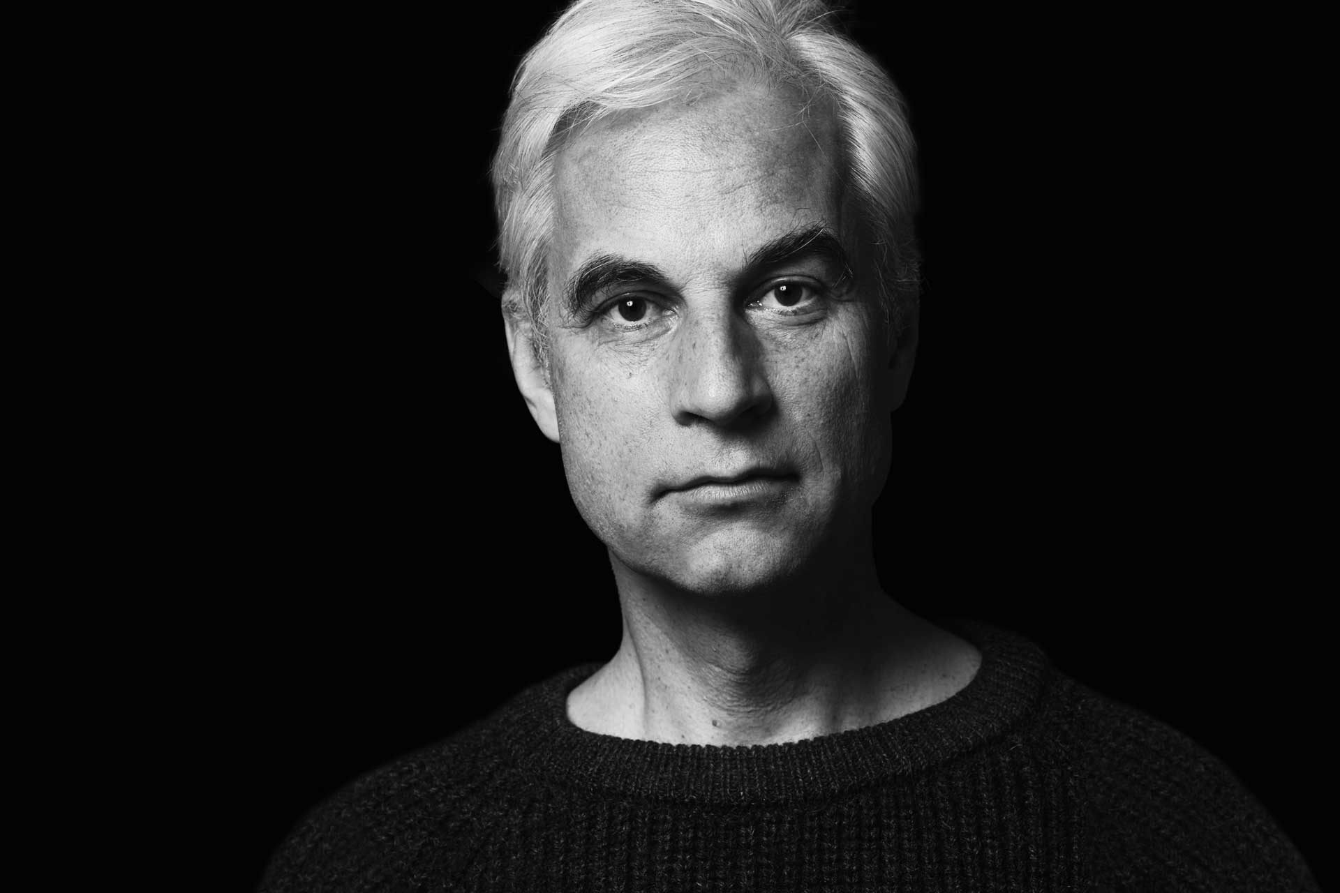 Schwarz-weißes Foto des Künstlers Hartmut Hellner, platziert neben dem offiziellen Zitat des Deutschen Pferdemuseums, das seine Bedeutung als einer der renommiertesten Pferdemaler unterstreicht.