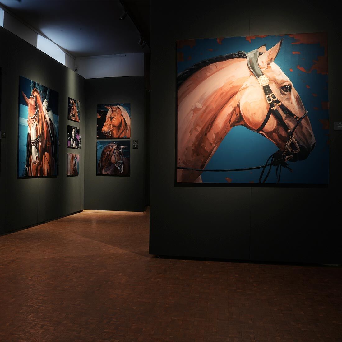 Ausstellungsansicht aus dem Deutschen Pferdemuseum mit einem großformatigen Pferdeporträt im Vordergrund, moderne Tiermalerei von Hartmut Hellner auf einer dunklen Galeriewand, Fokus auf die präzise Lichtführung und das ausdrucksstarke Profil des Pferdes.
